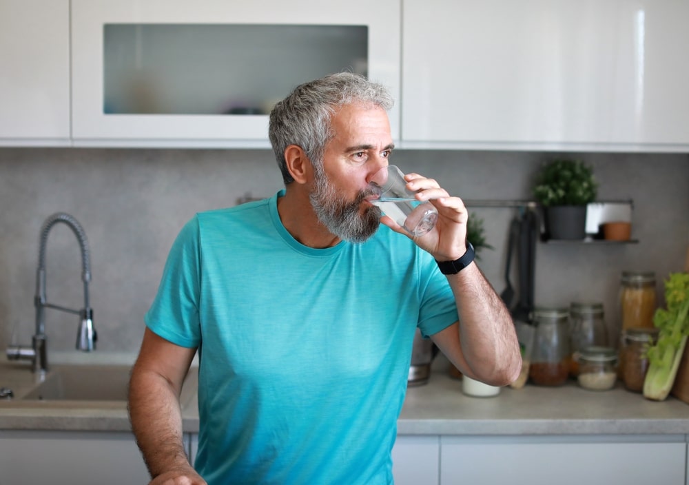 Homme d'âge mur qui prend un verre d'eau