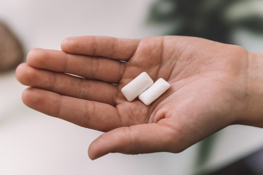 Deux carrés de gomme à mâcher dans une main