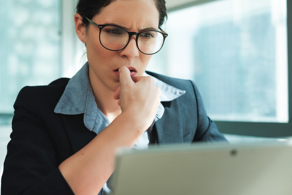 Femme stressée qui se ronge les ongles devant son ordinateur