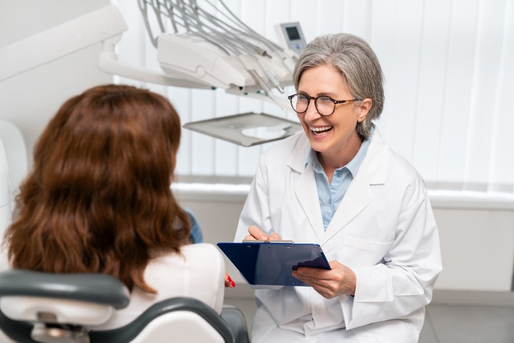 Femme dentiste qui explique un traitement à sa patiente
